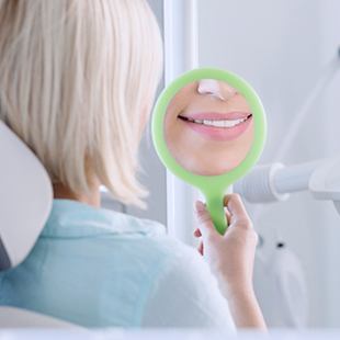 smile in dental mirror