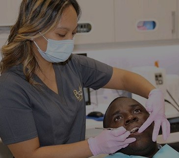 Dental hygienist examining patient's teeth