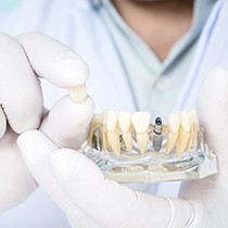 A dentist holds a mouth mold with a dental implant and its crown in Scarborough