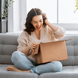 Woman sitting on couch with an open box